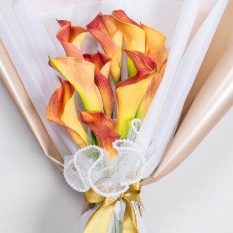 hermoso bouquet de lirios o lacas envuelto en fino papel blanco y dorado