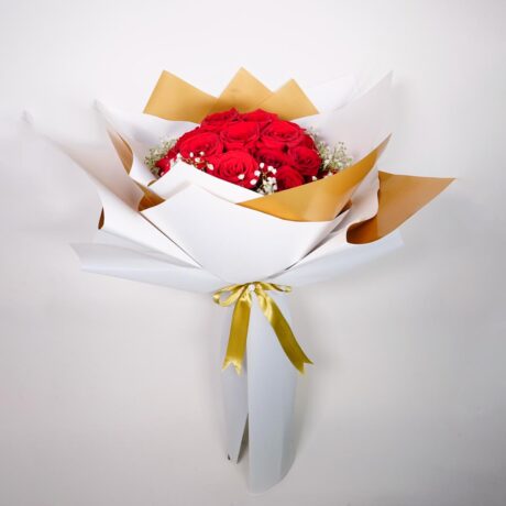 Bouquet de rosas ramo de rosas elegantes envueltas en papel elegante blanco y dorado