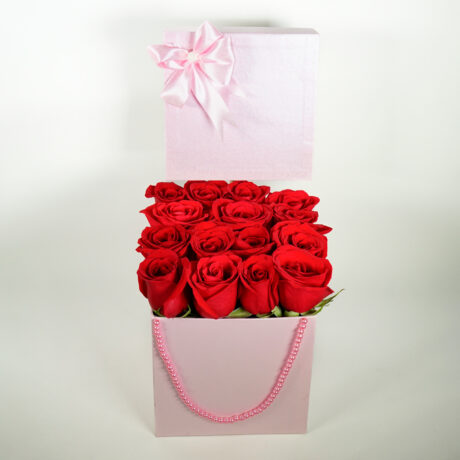 caja cuadrada rosada de rosas rojas con tapa , moño y perlas
