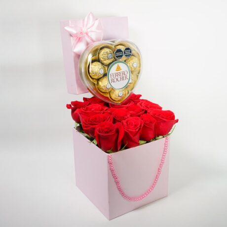 caja cuadrada rosada de rosas rojas con tapa , moño, perlas y chocolates ferrero rocher