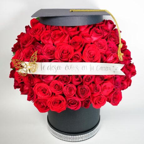 caja de muchas rosas rojas con base tambor negro y gorro de grado