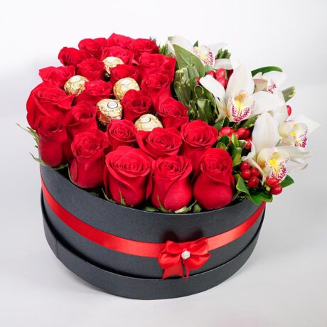 caja de flores rosas y orquideas con moño