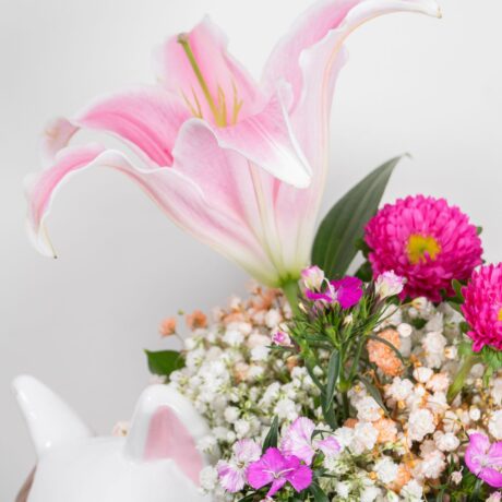 Florero con forma de perrito y flores purpura y lirio
