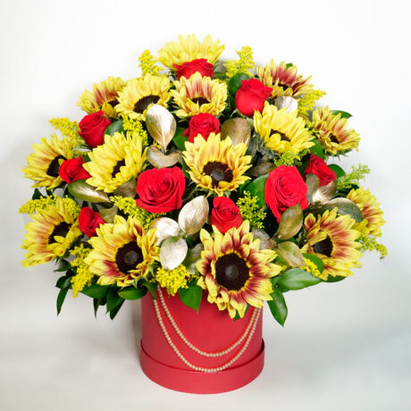 caja de girasoles y rosas con base roja y perlas